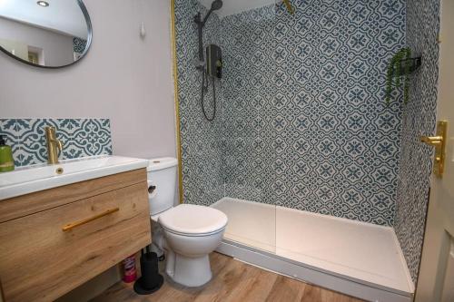 a bathroom with a toilet and a shower and a sink at Woodhall Spa - stylish, central flat in Lincolnshire