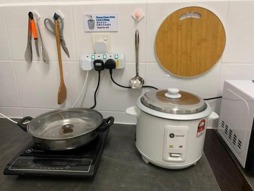 a slow cooker sitting on a stove in a kitchen at SSR Stay n rest 887芙蓉休闲站民宿 in Seremban