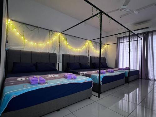 two beds in a room with lights on the wall at SSR Stay n rest 887芙蓉休闲站民宿 in Seremban