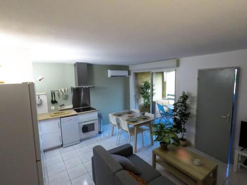 cocina y sala de estar con sofá y mesa en Appartement refait à neuf à 500m de la plage, en Torreilles
