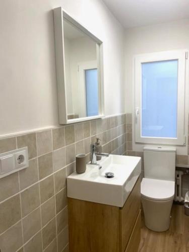 a bathroom with a sink and a toilet and a mirror at CENTRO GIJON CABRALES 31 in Gijón