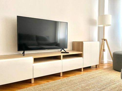 a flat screen tv sitting on a white entertainment center at CENTRO GIJON CABRALES 31 in Gijón