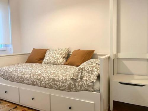 a white bed with pillows on it in a room at CENTRO GIJON CABRALES 31 in Gijón