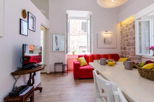a kitchen and a living room with a red couch at Midtown Apartments in Dubrovnik