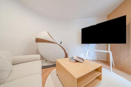 a living room with a white couch and a flat screen tv at Aank Hotel Daejeon Yongjeon 2nd in Daejeon