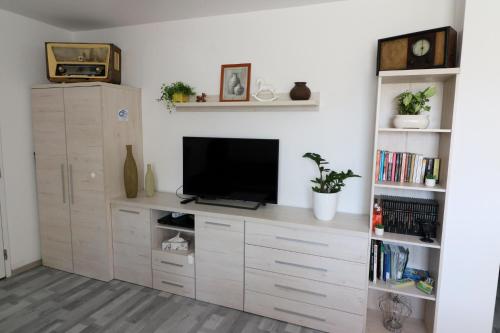 een woonkamer met een tv op een plank bij Cztery Kąty in Drawno