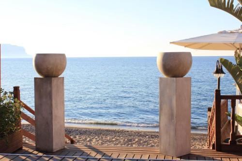 a view of the beach with two concrete pillars at Hotel La Martinica in Ficarazzi