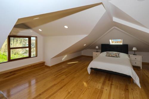 a attic bedroom with a bed and a window at Azores Haven Hill in Horta