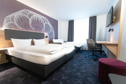 ein Hotelzimmer mit 2 Betten und einem Schreibtisch in der Unterkunft Taste Hotel Jettingen in Jettingen-Scheppach