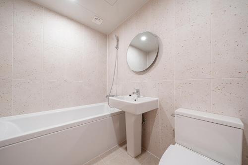 a bathroom with a sink and a toilet and a mirror at Aank Hotel Daejeon Yongjeon 2nd in Daejeon