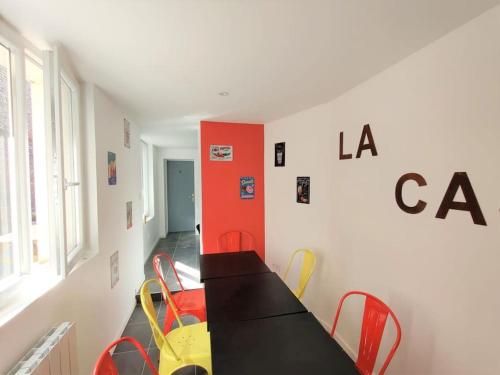 uma sala de jantar com uma mesa preta e cadeiras em La Casa - The Candy Cane em Amiens