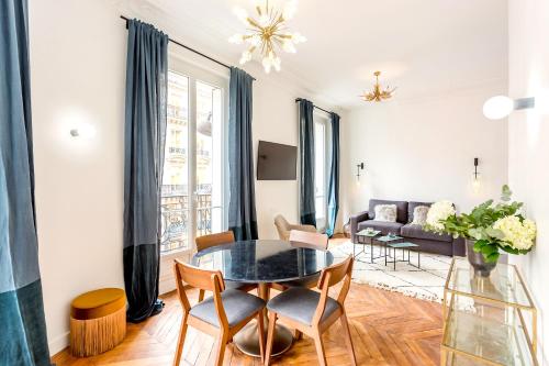 un salon avec une table, des chaises et un canapé dans l'établissement Habitat Parisien - 2BR-2BA - AC - Balcony - Opéra, à Paris