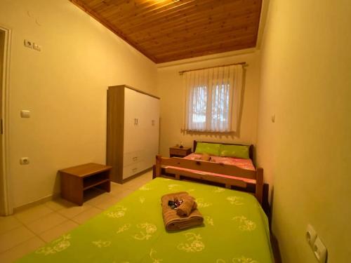1 dormitorio con 2 camas con sábanas verdes y ventana en Country-side residence, en Repanídhion