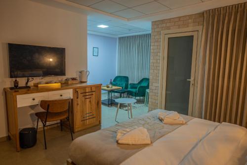 1 dormitorio con 1 cama, escritorio y sillas en Goland Hotel, en Mas'ada