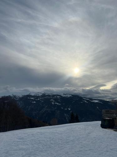a snow covered mountain with the sun in the sky at Grazioso trilocale nel cuore di Folgaria in Folgaria
