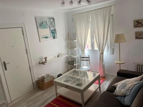 una sala de estar con una mesa de centro de cristal. en Stunning apartment at beach en Caldes d'Estrac