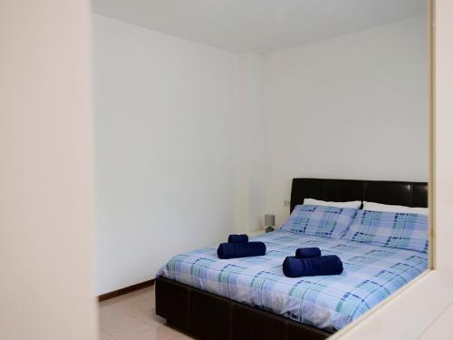 ein Schlafzimmer mit einem Bett mit zwei blauen Kissen darauf in der Unterkunft [house in color] in SantʼAntonio