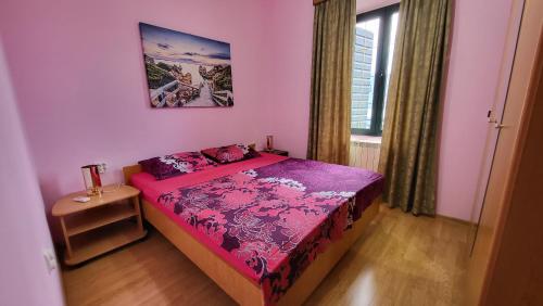 a small bedroom with a bed and a table at Apartment Capt Seferovic 2 in Donji Morinj