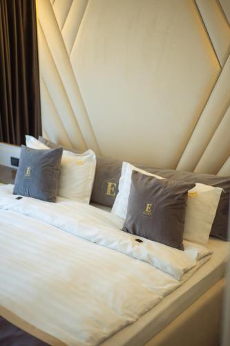 a bed with four pillows on top of it at Elexus Predeal in Predeal
