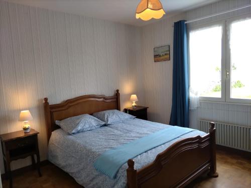 une chambre avec un lit avec des draps bleus et une fenêtre dans l'établissement Trouz Ar Mor, à Penmarcʼh