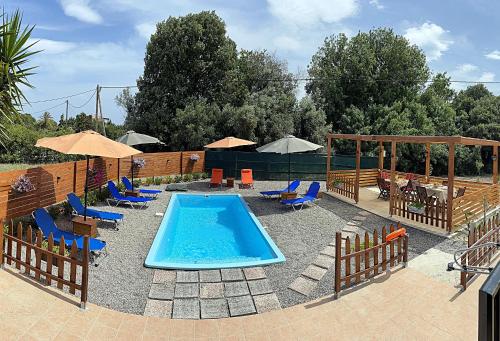 a swimming pool with chairs and umbrellas and a swimming pool at Filippos Green Villa in Ialysos