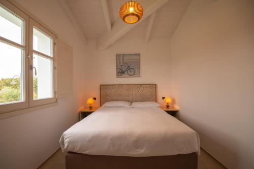 a bedroom with a bed and two lamps on two tables at ENAJA - Luxury Retreat in Budoni