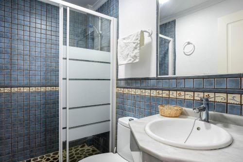 a bathroom with a sink and a toilet and a mirror at Casa Vistas al Mar Bolonia 2 in Tarifa