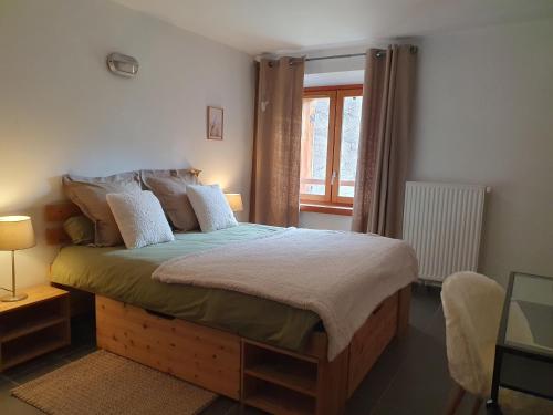 une chambre avec un grand lit et une fenêtre dans l'établissement Refuge Hôtel de Bayasse, à Uvernet