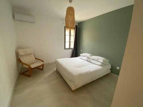 - une chambre avec un lit, une chaise et une fenêtre dans l'établissement Maison Diderot, à Aigues-Mortes