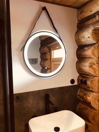 a bathroom with a round mirror above a sink at Blockhaus PanHütte in Braunlage