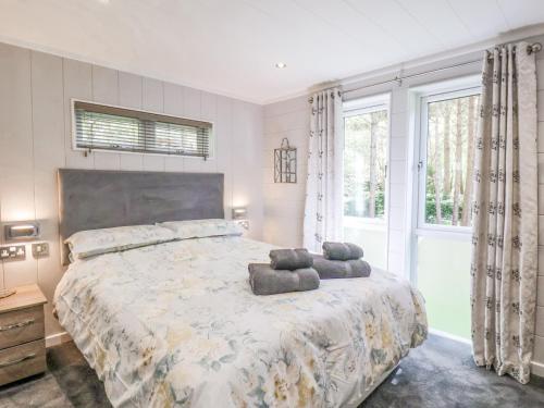 a bedroom with a large bed with a large window at Ewe Crag Beck Lodge in Whitby