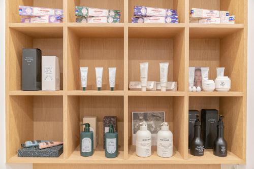 a wooden shelf with bottles ofodorizers and other products at The Hyoosik Aank Hotel Cheonan Station 2nd Branch in Cheonan