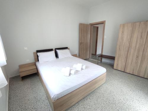 Schlafzimmer mit einem Bett mit weißer Bettwäsche und weißen Kissen in der Unterkunft NP Apartment in Megáli Panayía