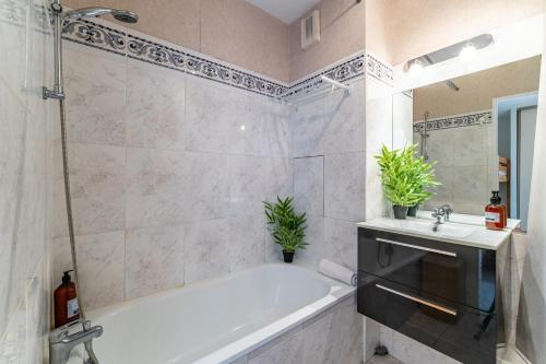 a bathroom with a bath tub and a sink at Alienor - Charmant appartement plein coeur dArcachon in Arcachon