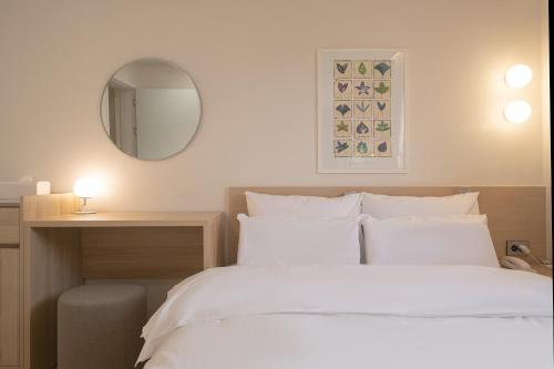 a bedroom with a white bed and a mirror at Aank Hotel Cheonan Station 2nd in Cheonan