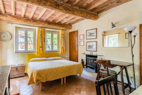 1 dormitorio con cama, escritorio y chimenea en Abbacca-là appartamento 2, en Lucca