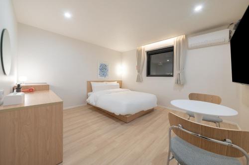 a bedroom with a bed and a table and a tv at Aank Hotel Cheonan Station 2nd in Cheonan