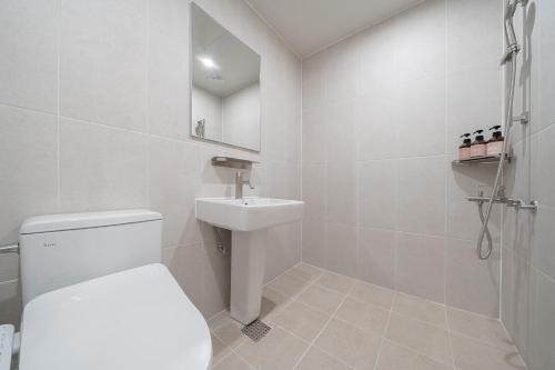 a white bathroom with a toilet and a sink at Aank Hotel Cheonan Station 2nd in Cheonan