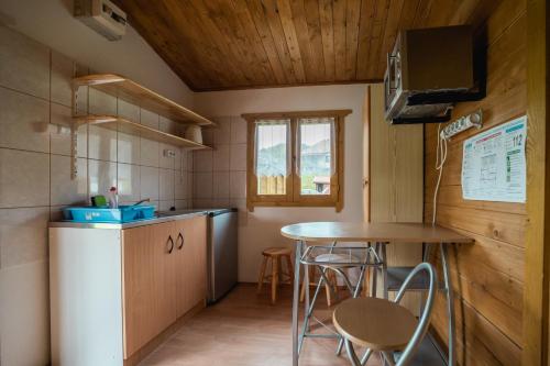 a small kitchen with a table and chairs in a room at Biotour Camping & Restaurant in Ghimeş