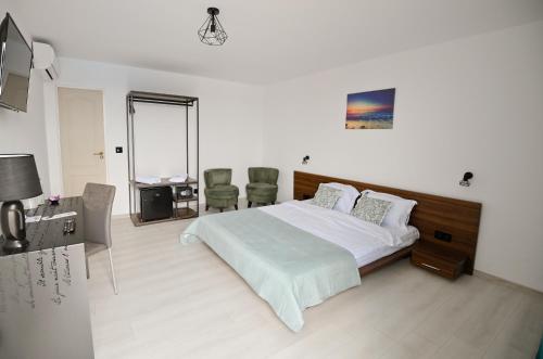 a bedroom with a bed and a table and chairs at Vila Medusa in Vama Veche