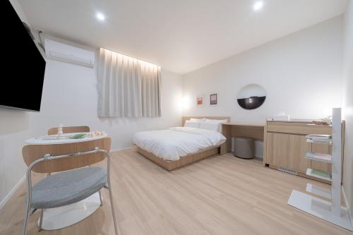 a bedroom with a bed and a desk and a sink at Aank Hotel Cheonan Station 2nd in Cheonan