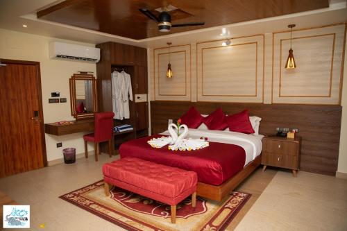 a bedroom with a large bed with a red bedspread at KC's Home in Sauraha