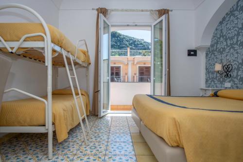 a bedroom with two bunk beds and a balcony at Hotel7Bello in Minori