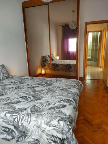 1 dormitorio con cama y espejo grande en A place to rest and enjoy, en Piedade