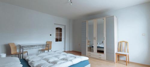 een witte slaapkamer met een bed en een bureau bij Apartman Stano-1 in Liptovský Mikuláš