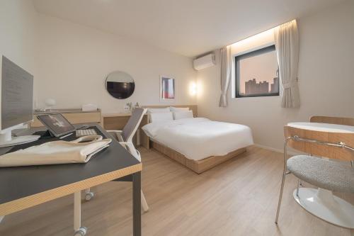 a hotel room with a bed and a desk with a computer at Aank Hotel Cheonan Station 2nd in Cheonan
