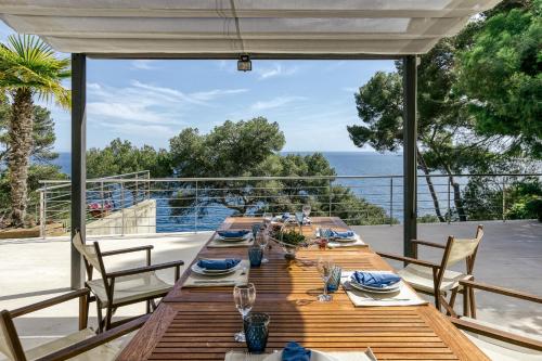 a table on a deck with a view of the ocean at Blueview Villa in Llafranc
