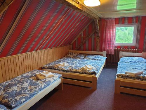 two beds in a room with red walls at Penzion Tereza in Telnice