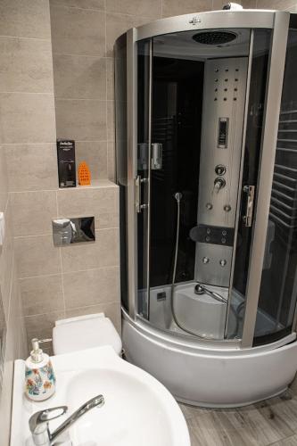 een badkamer met een douche, een wastafel en een toilet bij APARTAMENTY WYDMINY in Wydminy