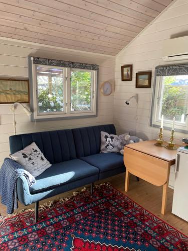 - un salon avec un canapé bleu et une table dans l'établissement Skagen hytte, à Skagen